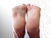 dark hair woman show her clean soft soles feet