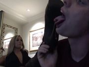 Val�s thigh high boots are cleaned to a high shine by the slave�s tongue