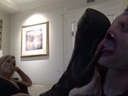 Val�s thigh high boots are cleaned to a high shine by the slave�s tongue