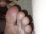 The teen boy lickling his foots